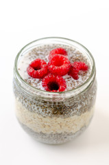 Chia seed pudding with oats and raspberries on white background close up