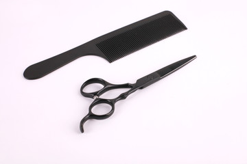 Barber scissors and a hairbrush isolated on white background