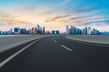 Fototapeta premium Foreground highway asphalt pavement city building commercial building office building