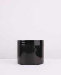 Black cosmetic containers on white background