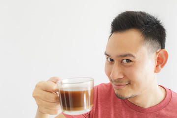 Healthy Asian man offer herbal drink in a glass cup.