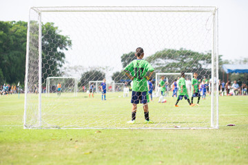 The goalkeeper who stands to watch friends play football. The view from behind the goal.