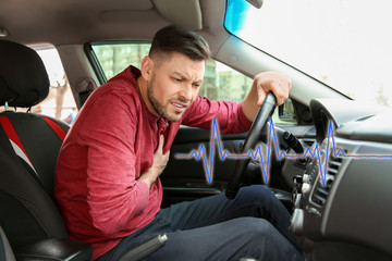 Obraz premium Mature man suffering from heart attack in car