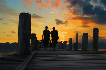 monk walking on U bain bridge at Mandalay under sunset,Myanmar