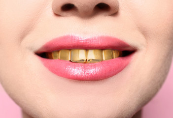 Beautiful young woman with gold teeth, closeup