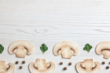 Sliced champignon mushrooms on wooden background, flat lay with space for text