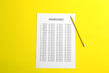 Answer sheet with pencil on color background, top view