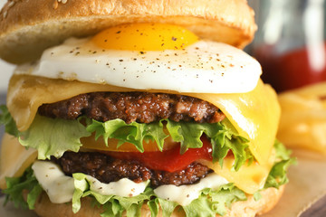 Closeup view of tasty burger with fried egg