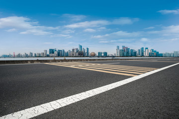 Fototapeta premium Foreground highway asphalt pavement city building commercial building office building