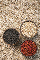 Organic white red and black pepper corns in wood display