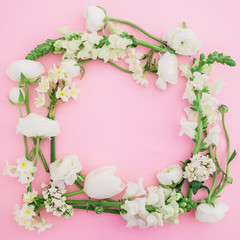 Floral pastel frame made of white flowers on pink background. Flat lay, top view