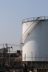 Obraz premium large white Industrial tanks for petrol and oil ,shadows of the stairs.
