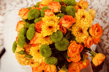 a bouquet of orange roses and yellow chrysanthemums