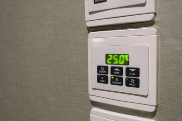 Wall-mounted air conditioning control buttons.