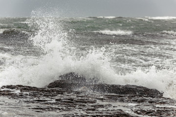 Splash of huge waves on a rocky shore