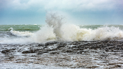 Splash of huge waves on a rocky shore