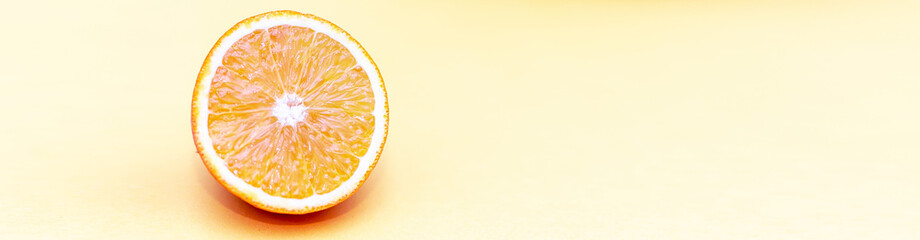 One circle slice of fresh ripe orange with pulp and peel on yellow and pink background. Top view. Clipping path - image