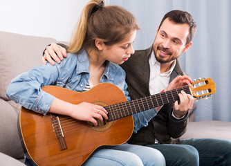 Guitar tutor helping client learn instrument