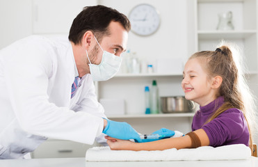 Fototapeta premium Male doctor injecting little patient