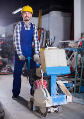 Worker is using gas saw for construction work