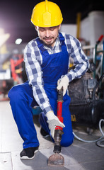 Worker work with demolition hammer