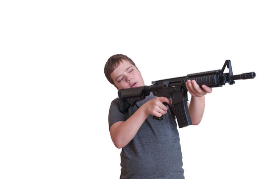 the boy holds a rifle gun and aims to the side. isolate