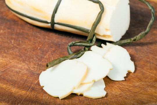 sliced Provola Affumicata cheese on board close up