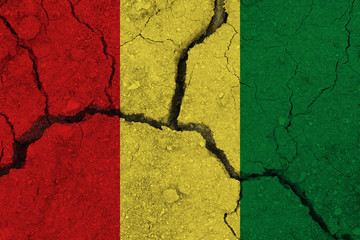 Guinea flag on the cracked earth