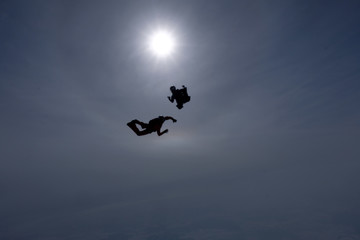 The team of two skydivers is training in the sky.