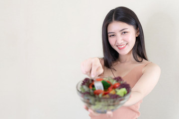 Beautiful beauty woman Asian cute girl feel happy eating diet food fresh salad for good health in the morning , enjoying time in her home white bedroom background - lifestyle beauty woman concept