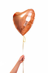 One big pink gold heart ball object for birthday, Valentine's day. in the hand of man. isolated on white background.