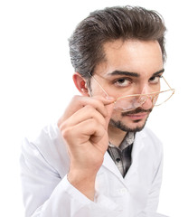 A fun shot of a confident person in a lab coat looking through his glasses with acknowledgment and...