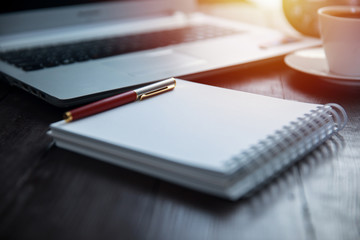 pen on notepad with computer