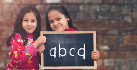 Two little Indian Rural girls holding slate board