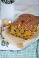 Carrot loaf cake with shiny glaze and nuts on white wooden background close up selective focus