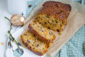 Carrot loaf cake with shiny glaze and nuts on white wooden background close up selective focus
