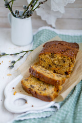 Carrot loaf cake with shiny glaze and nuts on white wooden background close up selective focus