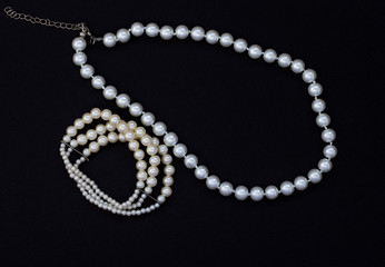 women's jewelry with pearls on black background