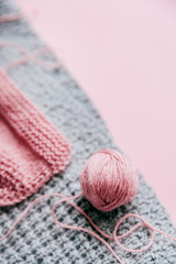 Grey and violet  knitted fabric with yarn skein on a pink background