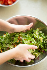 Hands mixing mixed leaves salad preparation