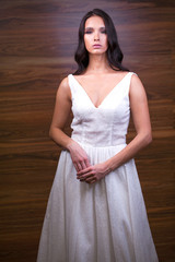 Portrait close up of young beautiful brunette woman in white dress