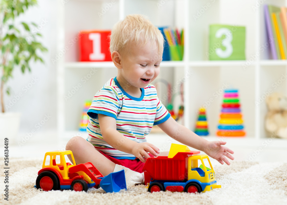 Wall mural nursery baby toddler playing with toys in kindergarten