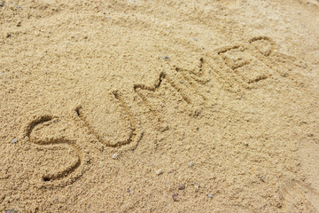 Fototapeta na wymiar Summer word written on the sand at the beach, natural background