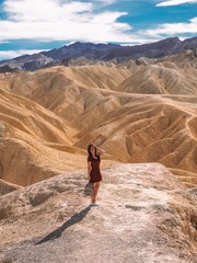 The girl in the red dress with long hair standing overlooking Zabriski point in Death Valley