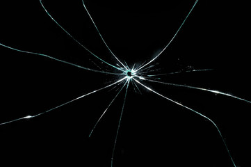 broken cracked glass with hole in black background
