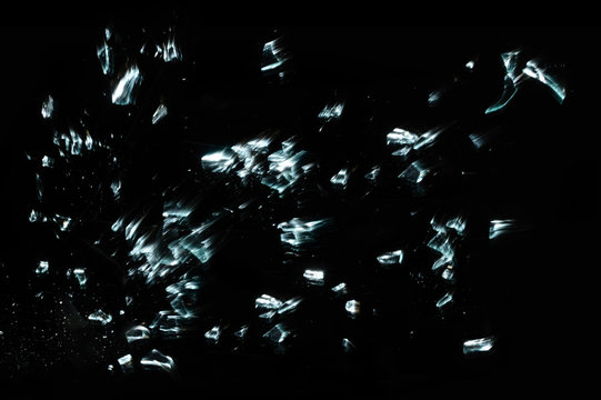 Shattered and splitted glass pieces isolated on black with motion