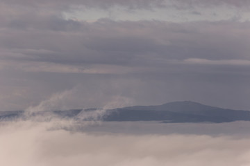 Fototapeta premium Fog filling a valley in Umbria (Italy), with layers of mountains and hills, various shades of blue