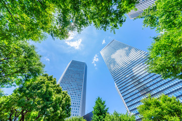 Obraz na płótnie Canvas Asia Business concept for real estate, corporate construction and ecology - looking up view of panoramic modern city skyline with blue sky and green tree in shinjuku, tokyo, japan