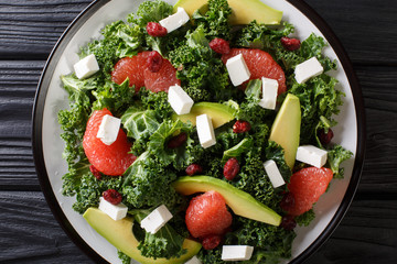Fitness salad of kale, avocado, grapefruit, feta and dried cranberries close-up on a plate. horizontal top view
