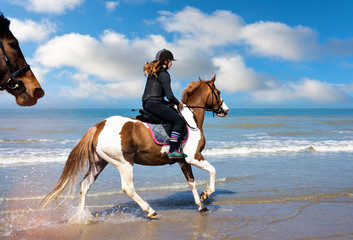 jeune cavalière au galop sur la plage